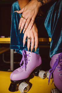 girl wearing roller skates and velvet outfit with pastel wavy press on nails