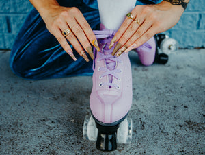 girl wearing blue velvet and cute trippy heart press on nails typing her roller skates