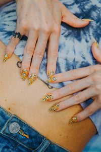 girl wearing cute outfit wearing clear yellow fake nails