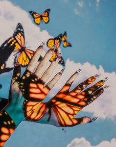 projector photography using butterflies with clouds and two hands wearing long stiletto press on nails