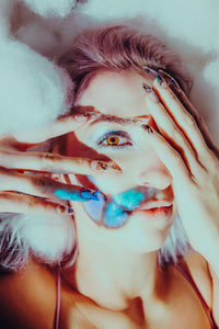 girl in clouds with butterfly on her face and wearing long stiletto fake nails with butterflies