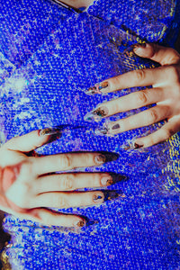 girl wearing holographic shiny sequin dress and wearing long clear butterfly press on nails