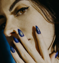 Load image into Gallery viewer, girl wearing press on nails with close up of dark blue nails with matte finish and gold astrology designs