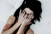 Load image into Gallery viewer, girl with black hair and tattoos with hands covering face wearing matte black almond shaped fake nails with witchy symbols